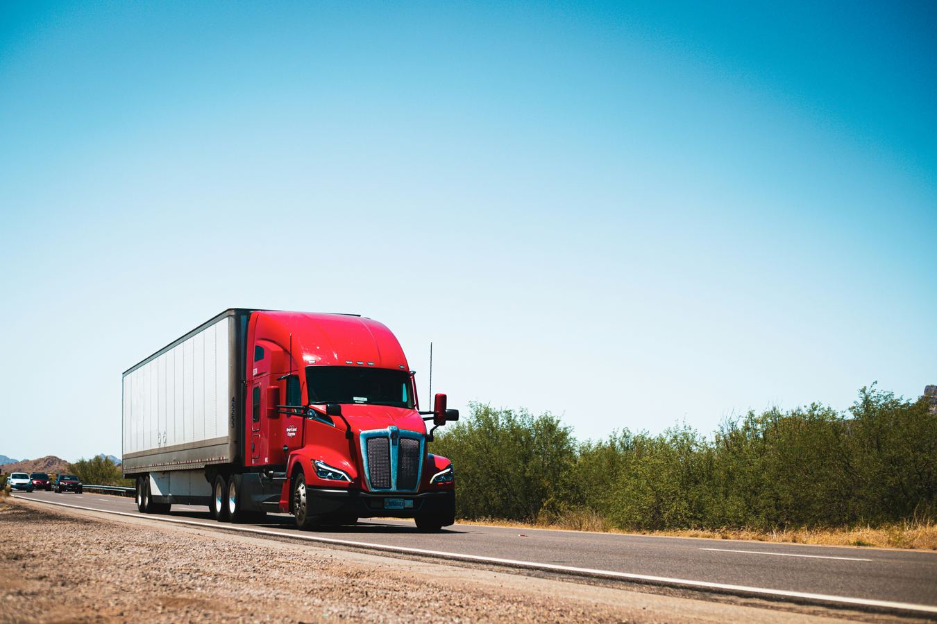 Red semi truck traveling on an open highway